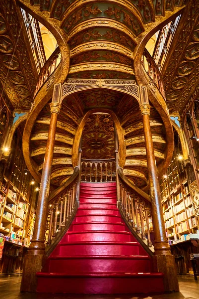 Gran escalera de madera con escalones rojos dentro de la librería Livraria Lello en el centro histórico de Oporto, famosa por la película de Harry Potter . — Foto de Stock