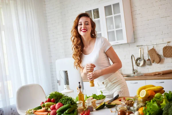 실내 녹색 신선한 재료와 아름다운 부엌에서 맛있는 샐러드를 준비하는 젊은 행복한 여성. 건강한 음식과 다이어트 개념. 체중 감량 — 스톡 사진