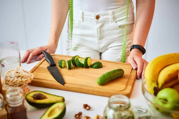 실내에서 녹색 신선한 재료와 아름다운 부엌에서 샐러드를 만들기위한 오이를 절단 젊은 행복한 여성. 건강한 음식과 다이어트 개념. 체중 감량 — 스톡 사진
