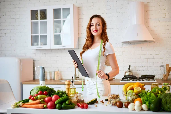 현대 부엌에서 요리 하는 동안 태블릿을 사용 하 여 젊은 아름 다운 여자. 건강한 식습관, 비타민, 다이어트, 기술 및 사람 개념. 체중 감량 — 스톡 사진