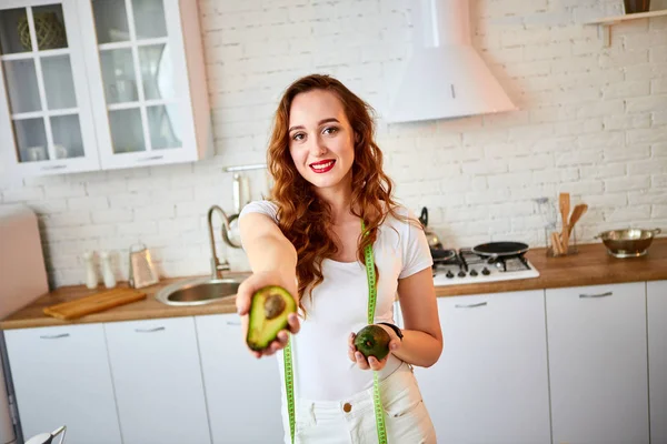Fiatal boldog nőt gazdaság avokádó készítésére saláta a gyönyörű konyhában, zöld friss alapanyagokból beltéri. Egészséges táplálkozás és a fogyókúra fogalmát. Elvesztése súly — Stock Fotó