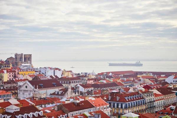 Lisboa Portugal - Hermosa vista panorámica de los tejados rojos de las casas en el antiguo barrio histórico de Alfama y el río Tajo y puente desde el Castillo de Sao Jorge — Foto de Stock