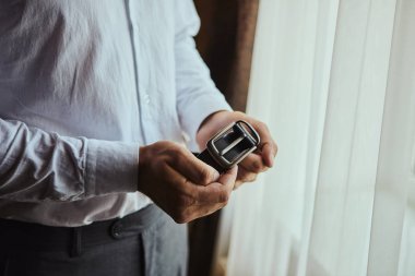 İş adamı kemer takıyor, moda ve giysi konsepti, damat törenden önce sabah hazırlanıyor.