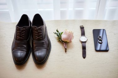 Bir iş adamının farklı aksesuarları ahşap bir arka planda yatar.