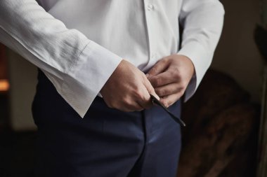 İş adamı kemer takıyor, moda ve giysi konsepti, damat törenden önce sabah hazırlanıyor.