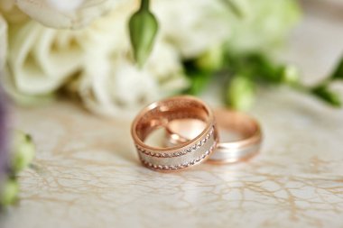 Alyanslar gelin buketinin yanında duruyor.