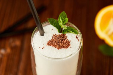 Tarçınlı ve ahşap zemin üzerinde nane ile süslenmiş lezzetli milkshake.