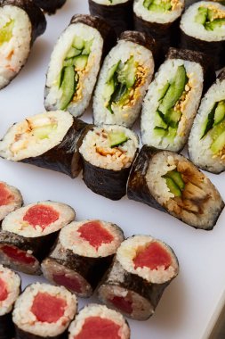 Kesme tahtasında çeşitli suşi ruloları servis ediliyor. Japon yemeği.