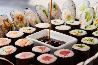 Kesme tahtasında çeşitli suşi ruloları servis ediliyor. Japon yemeği.