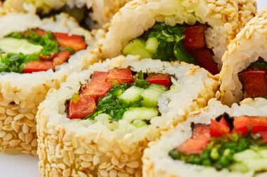 Salatalıklı vejetaryen suşi, tatlı biber ve beyaz arka planda uyanmış yosun.