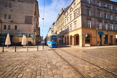 Wroclaw / Polonya - Mayıs 2019: Şehrin tarihi merkezinde dar asfalt bir caddede modern mavi tramvay. Polonya 'da toplu taşıma
