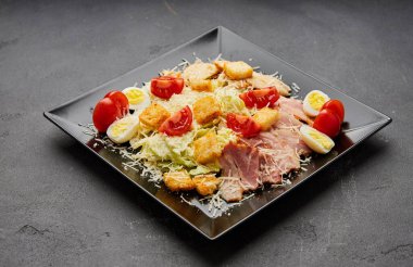 Marullu Sezar salatası, tavuk, pastırma ve kızarmış ekmek.