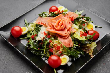 Somon ve kırmızı havyarla servis edilen taze deniz ürünleri salatası.