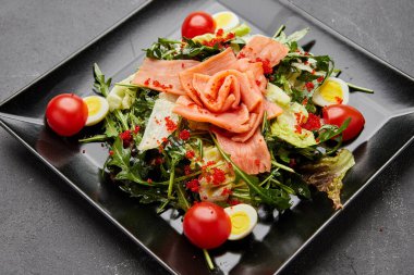 Somon ve kırmızı havyarla servis edilen taze deniz ürünleri salatası.