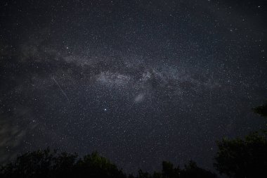 Parlak yıldızlı bir gece gökyüzü ve Karpat dağlarında kayan yıldızlar 