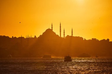 İstanbul Silhouette üzerinde gün batımında, feribot ve feribotlarla birlikte. Günbatımında minare siluetleriyle geleneksel Arap kasabası, Türkiye 'de İslam mimarisinin antik simgeleri.