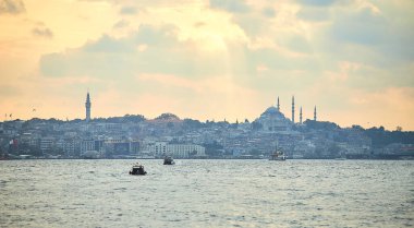 İstanbul 'da gün batımında Süleyman Camii, şehir feribot ve tekne manzaralı. Günbatımında minare siluetleriyle geleneksel Arap kasabası, Türkiye 'de İslam mimarisinin antik simgeleri.