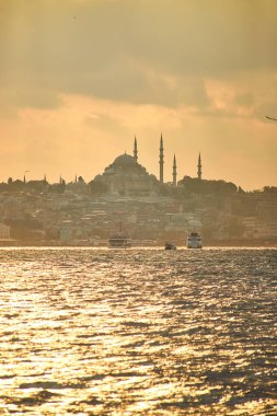 İstanbul 'da gün batımında Süleyman Camii, şehir feribot ve tekne manzaralı. Günbatımında minare siluetleriyle geleneksel Arap kasabası, Türkiye 'de İslam mimarisinin antik simgeleri.