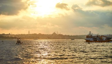 İstanbul 'da gün batımında Süleyman Camii, şehir feribot ve tekne manzaralı. Günbatımında minare siluetleriyle geleneksel Arap kasabası, Türkiye 'de İslam mimarisinin antik simgeleri.