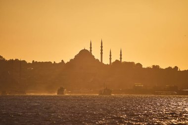 İstanbul Silhouette üzerinde gün batımında, feribot ve feribotlarla birlikte. Günbatımında minare siluetleriyle geleneksel Arap kasabası, Türkiye 'de İslam mimarisinin antik simgeleri.