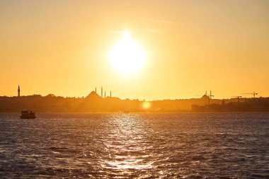 İstanbul Silhouette üzerinde gün batımında, feribot ve feribotlarla birlikte. Günbatımında minare siluetleriyle geleneksel Arap kasabası, Türkiye 'de İslam mimarisinin antik simgeleri.