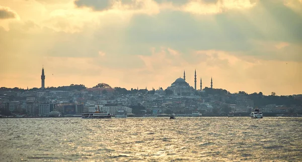 日落笼罩在伊斯坦布尔上空 俯瞰苏莱曼尼亚清真寺 城市轮渡和船只 具有日落时尖塔轮廓的传统阿拉伯城镇 土耳其穆斯林建筑的古老地标 — 图库照片