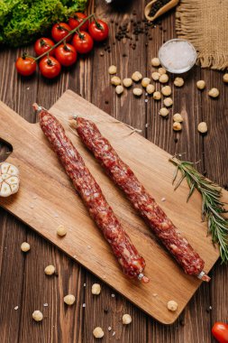 Ahşap kesim tahtasının üzerinde fındık, sarımsak ve biberiye ile sade sosis. Yüksek kalite fotoğraf