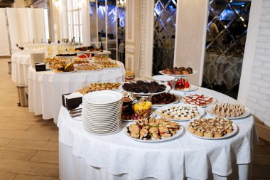 Şenlik şöleninde gurme kanepeler, tatlılar ve meyvelerle nefis bir açık büfe masası. Yüksek kalite fotoğraf