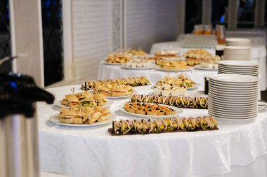 Açık büfe masasında çeşitli mini sandviçler ve yemek servisi için aperatifler var. Yüksek kalite fotoğraf