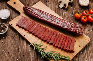 Dilimlenmiş sosis, ahşap tahta, baharat ve kırsal gıda tasarımı. Yüksek kalite fotoğraf