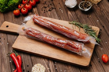 Tahta tahtada kurutulmuş sosisler, baharatlar ve taze sebzeler. Yüksek kalite fotoğraf