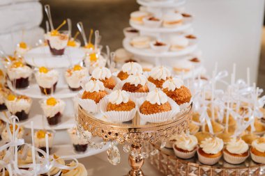 Lüks kekler, kurabiyeler, kurabiyeler ve zarif altın tepsilerde tatlılar. Yüksek kalite fotoğraf