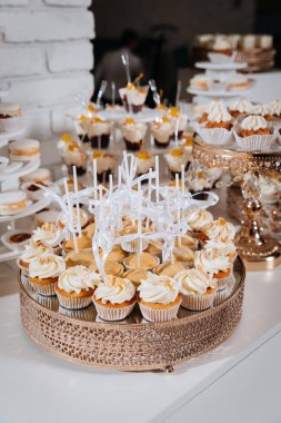 Festivalde çeşitli mini kekler ve kremalı kekler olan zarif bir tatlı masası. Yüksek kalite fotoğraf