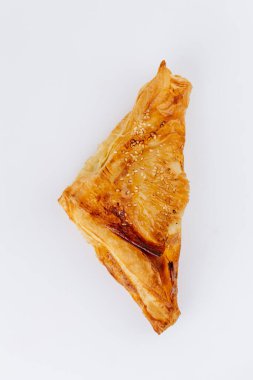 Beyaz arka planda izole edilmiş susam tohumlu altın puf böreği üçgenleri. Yüksek kalite fotoğraf