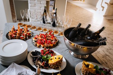 Şık bir etkinlikte abur cubur, şampanya şişeleri ve bardaklarla lüks yemek masası. Yüksek kalite fotoğraf