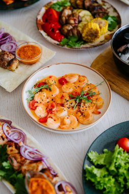Kremalı baharatlı karides, vişneli domates ve seramik kasede şifalı otlar. Yüksek kalite fotoğraf
