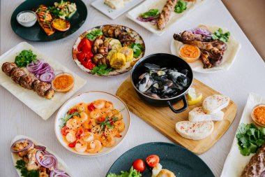 Restoran masasında çeşitli ızgara etler, deniz ürünleri ve mezeler. Yüksek kalite fotoğraf