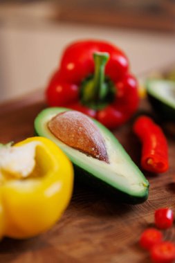 Köy ahşap mutfak masasında tohum, dolmalık biber ve kırmızı biber ile taze avokado yakın plan. Yüksek kalite fotoğraf