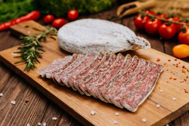 Geleneksel kurutulmuş salam sosisi, otlu ve kiraz domatesli köy ahşabı.