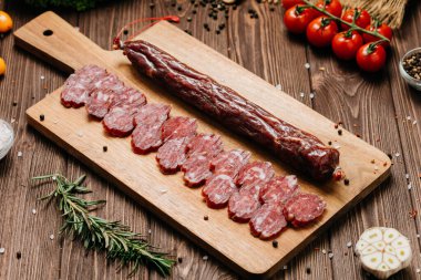 Köy ahşap tahtasında dilimlenmiş sosis, baharatlar ve domatesler, üst manzara. Yüksek kalite fotoğraf