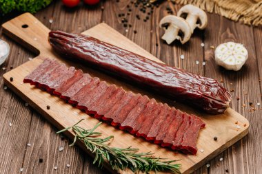 Dilimlenmiş sosis, ahşap tahta, baharat ve kırsal gıda tasarımı. Yüksek kalite fotoğraf