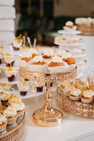 Festivalde çeşitli mini kekler ve kremalı kekler olan zarif bir tatlı masası. Yüksek kalite fotoğraf