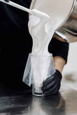 Profesyonel mutfakta pasta hazırlamak için boru torbasına poğaça döküyorum. Yüksek kalite fotoğraf