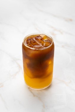 Mermer masada şeffaf bir bardakta portakal suyu ile buzlu kahve kokteyli tazeliyorum. Yüksek kalite fotoğraf