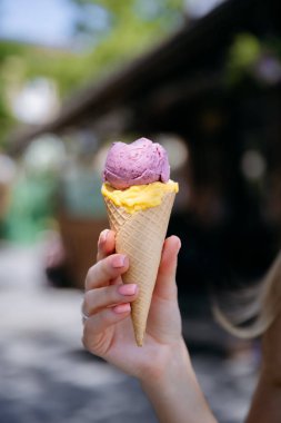 Açık havada çift kepçe mango ve çilekli dondurma ile el ele tutuşan waffle külahı. Yüksek kalite fotoğraf