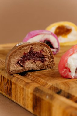 Ahşap tahtada çeşitli renkli mochi dondurmalar, yakın çekim manzarası, stüdyo ışıkları. Yüksek kalite fotoğraf