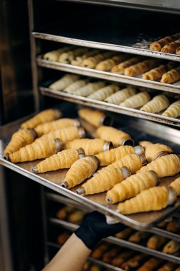 Profesyonel mutfakta altın krema boynuzları olan fırın örtüsü, pasta üretim süreci. Yüksek kalite fotoğraf