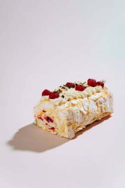 Pembe arka planda ahududu kremalı pasta ve şenlikli bir süsleme. Yüksek kalite fotoğraf