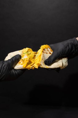 Ellerinde erimiş peynir ambalajı ve koyu arkaplanda siyah eldivenler. Yüksek kalite fotoğraf