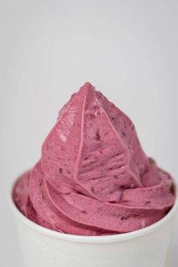 Beyaz bardakta canlı pembe meyveli dondurma, arka planda yakın çekim. Yüksek kalite fotoğraf